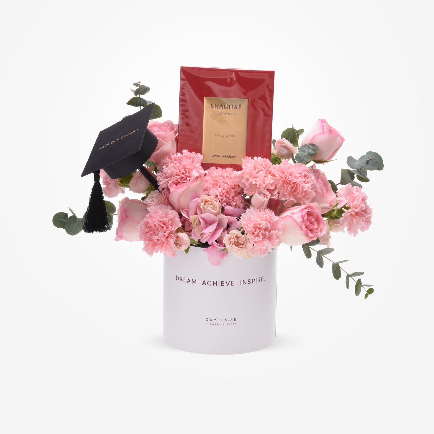 Pink roses and carnations in white vase with graduation cap and Shaghaf perfume.