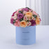 Pastel pink, purple, and peach roses in light blue box reading "It&