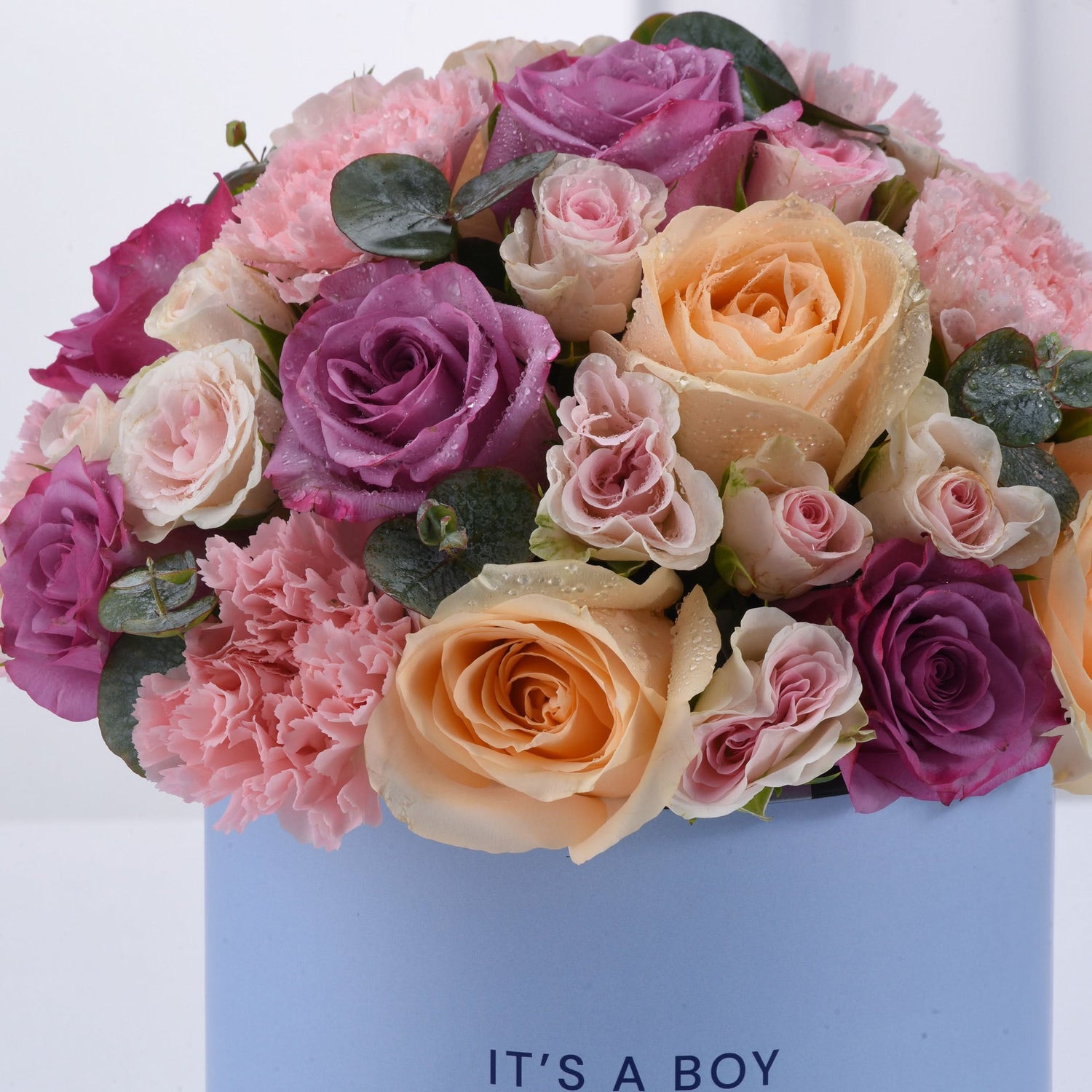 Pastel pink, purple, and peach roses with carnations and dewdrops in a blue "It&