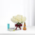 White roses in glass vase with burgundy bow, beside Strepsils, honey, and electrolyte.