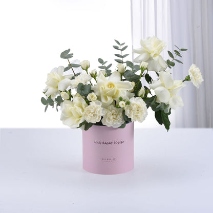 Elegant white rose and carnation bouquet in pink cylinder, adorned with eucalyptus, dewdrops, and Arabic "Happy Birthday Girl" text.