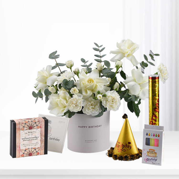 Elegant white roses in gray "Happy Birthday" vase with gold party hat and caramel gift.