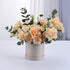 Soft peach roses and carnations in elegant beige hat box with eucalyptus.