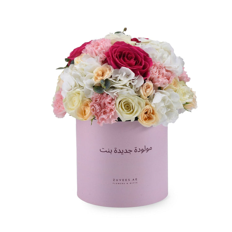 Pink box holds vibrant roses, carnations, and hydrangeas for baby girl celebration.
