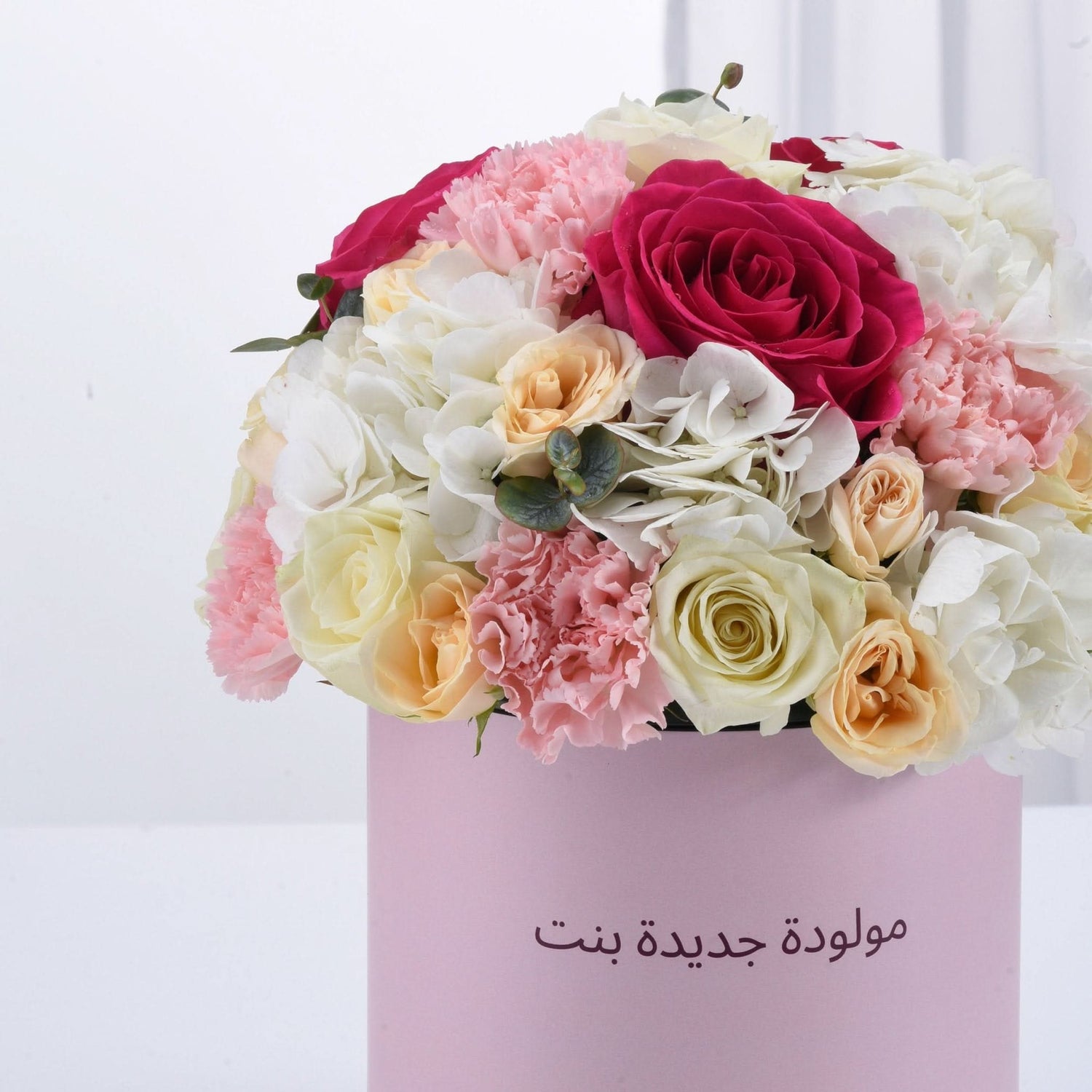 Pink box holds vibrant roses, carnations, and hydrangeas—perfect baby girl birthday gift.