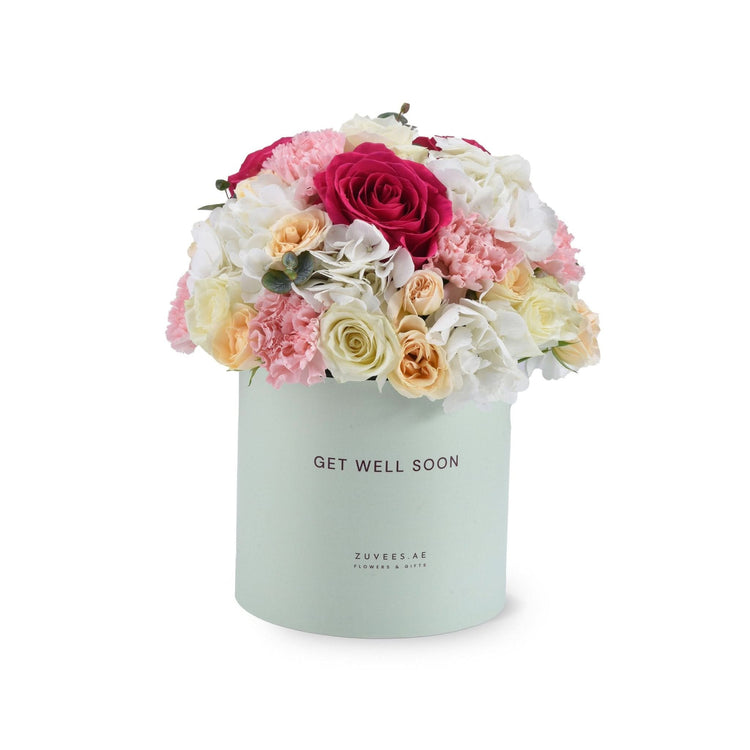 Pastel mint box holds vibrant pink, white, and peach blooms with "Get Well Soon" message.
