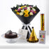 Vibrant multi-colored roses, chocolate cake, and festive birthday accessories arranged elegantly.