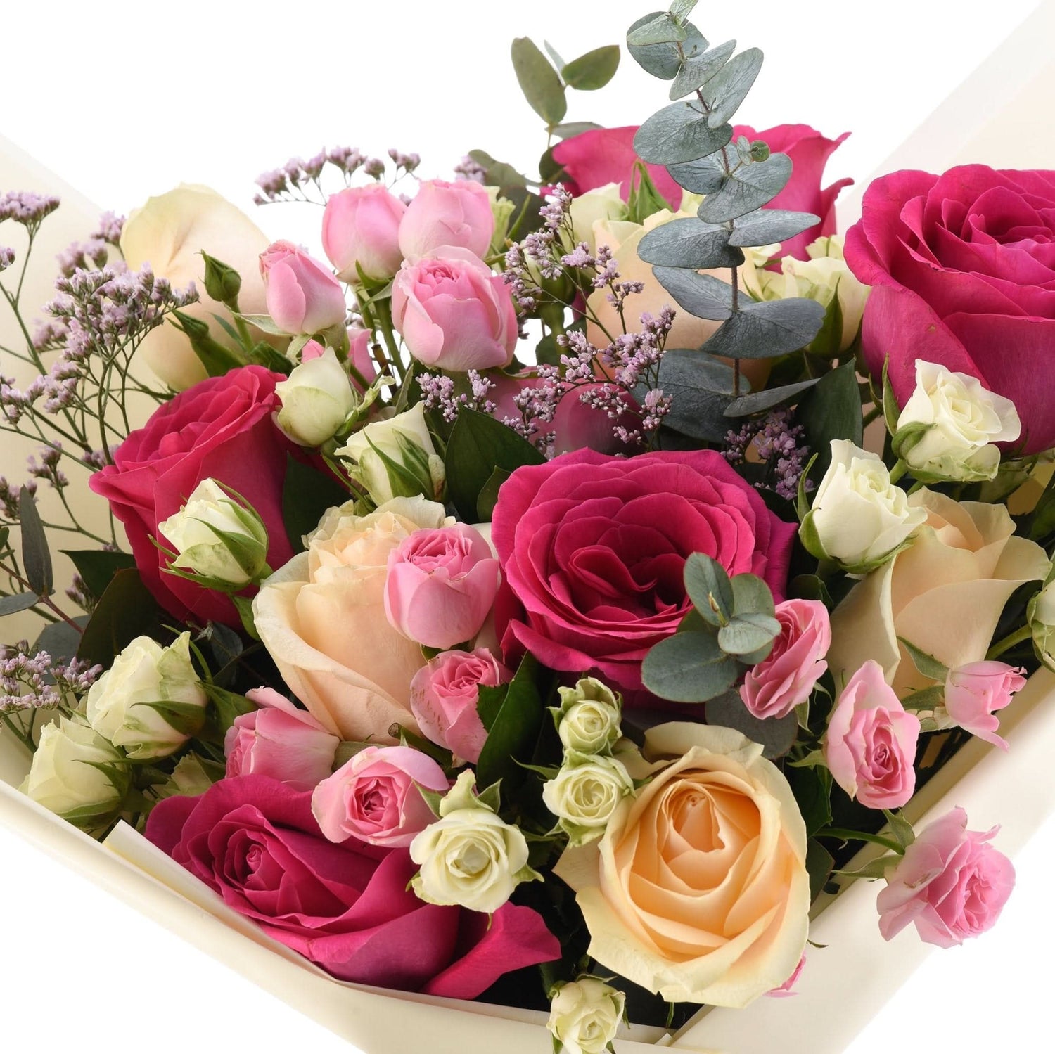 Vibrant bouquet of pink, magenta, and cream roses with eucalyptus and lavender accents.