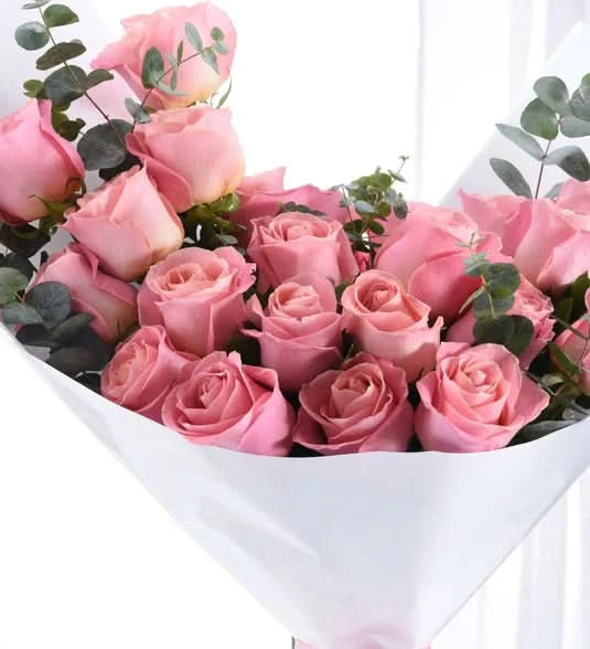 Soft pink roses with eucalyptus, elegantly wrapped in white paper.