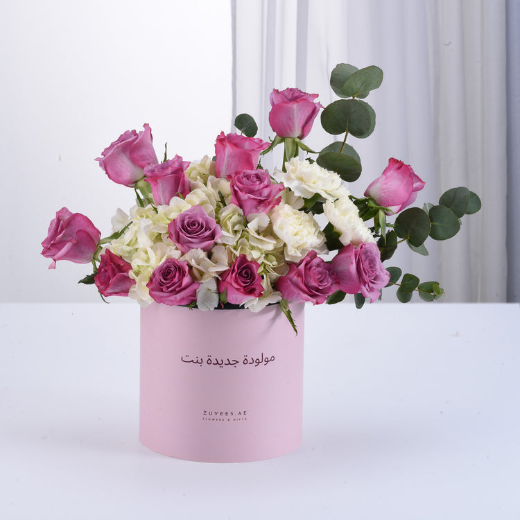 Pink roses, white hydrangeas, eucalyptus in soft pink gift box, elegant floral arrangement.
