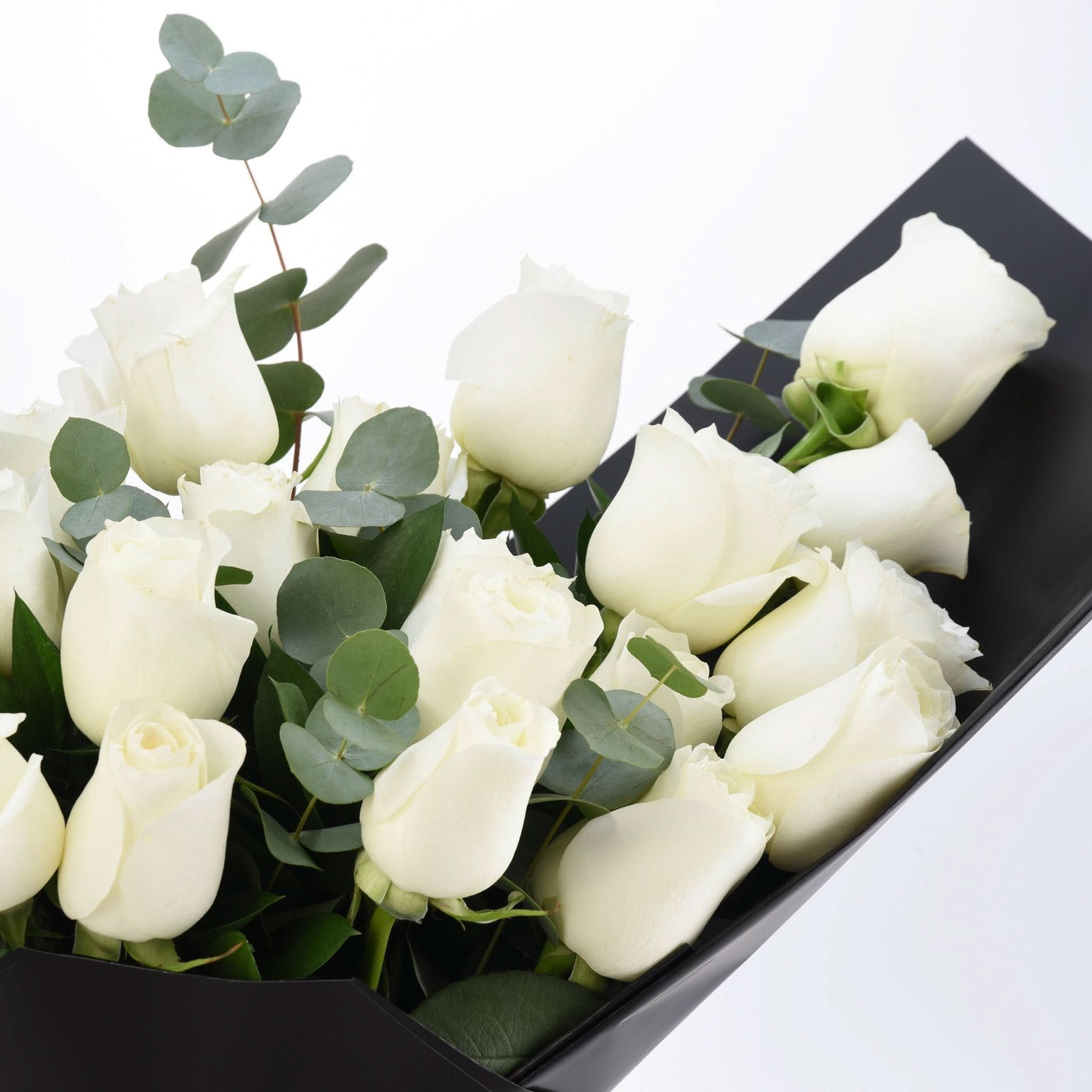 Elegant white roses with eucalyptus, nestled in sleek black wrapping.