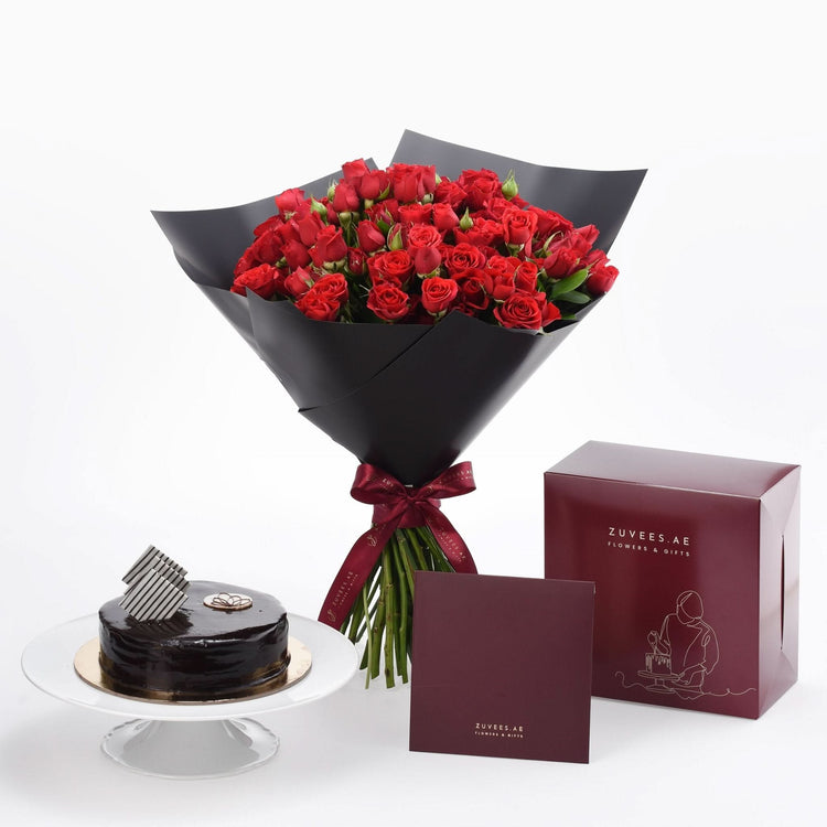 Luxurious red roses in black wrap paired with chocolate cake and branded gift box.