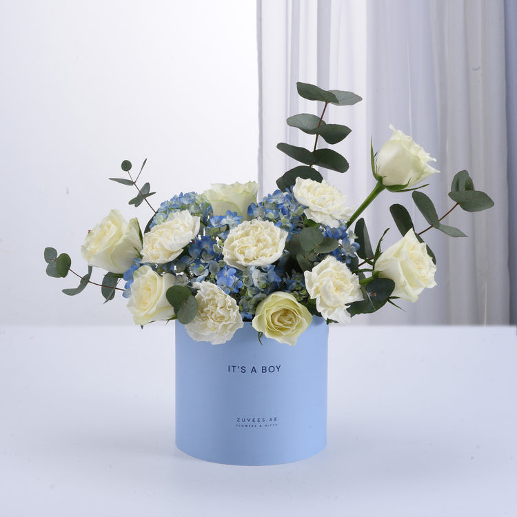 Light blue box holds white roses and blue hydrangeas, "It&