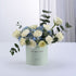 Pastel green box holds white roses and blue hydrangeas, “Get Well Soon” message.
