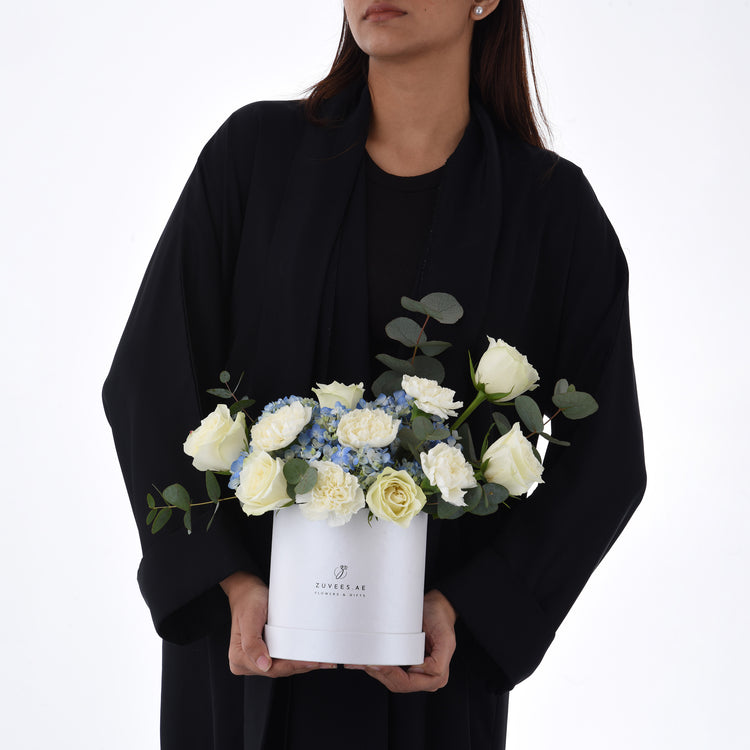 Elegant white rose and blue hydrangea bouquet in branded white box.