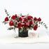 Bold red and pink roses in black cylinder vase with Valentine’s card.