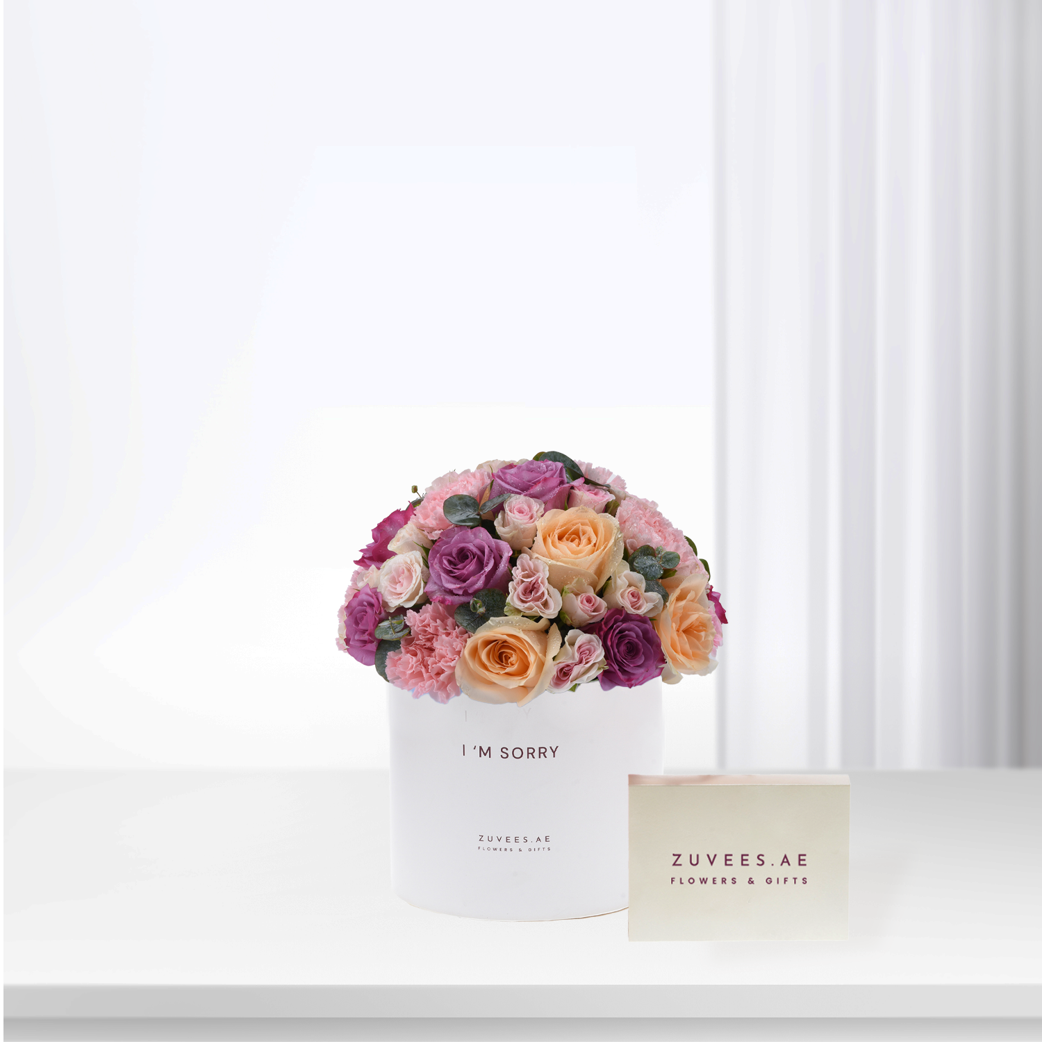 White box holds vibrant pink, purple, peach roses with “I&