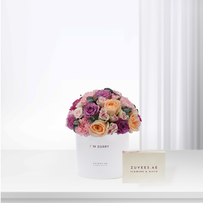 White box holds vibrant pink, purple, peach roses with “I&