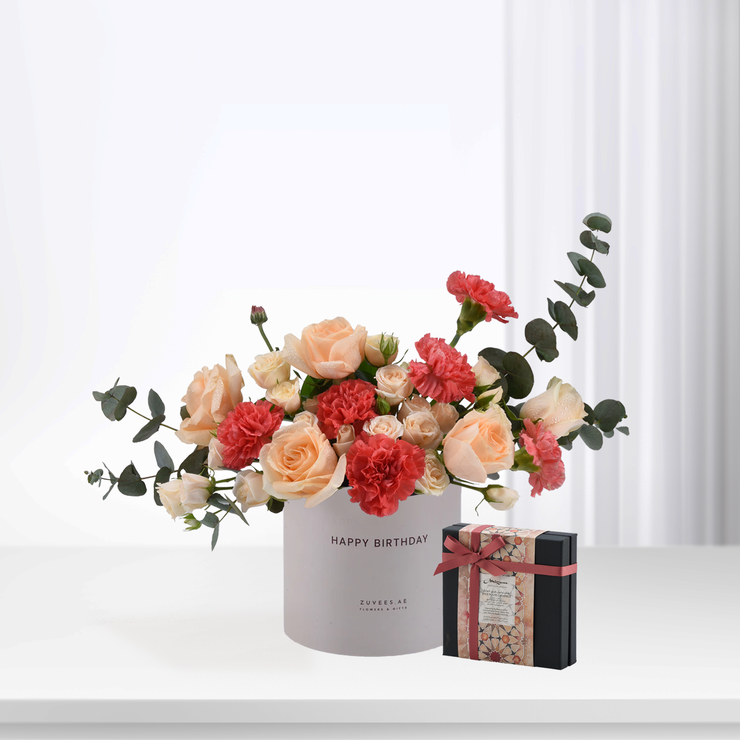 Pastel peach roses and red carnations in white box with "Happy Birthday" text.