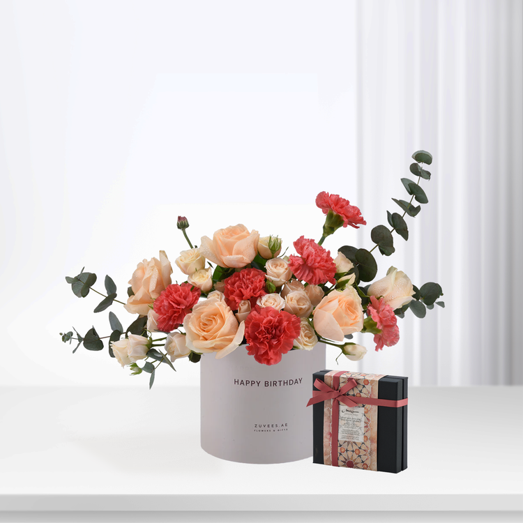 Pastel peach roses and red carnations in white box with "Happy Birthday" text.