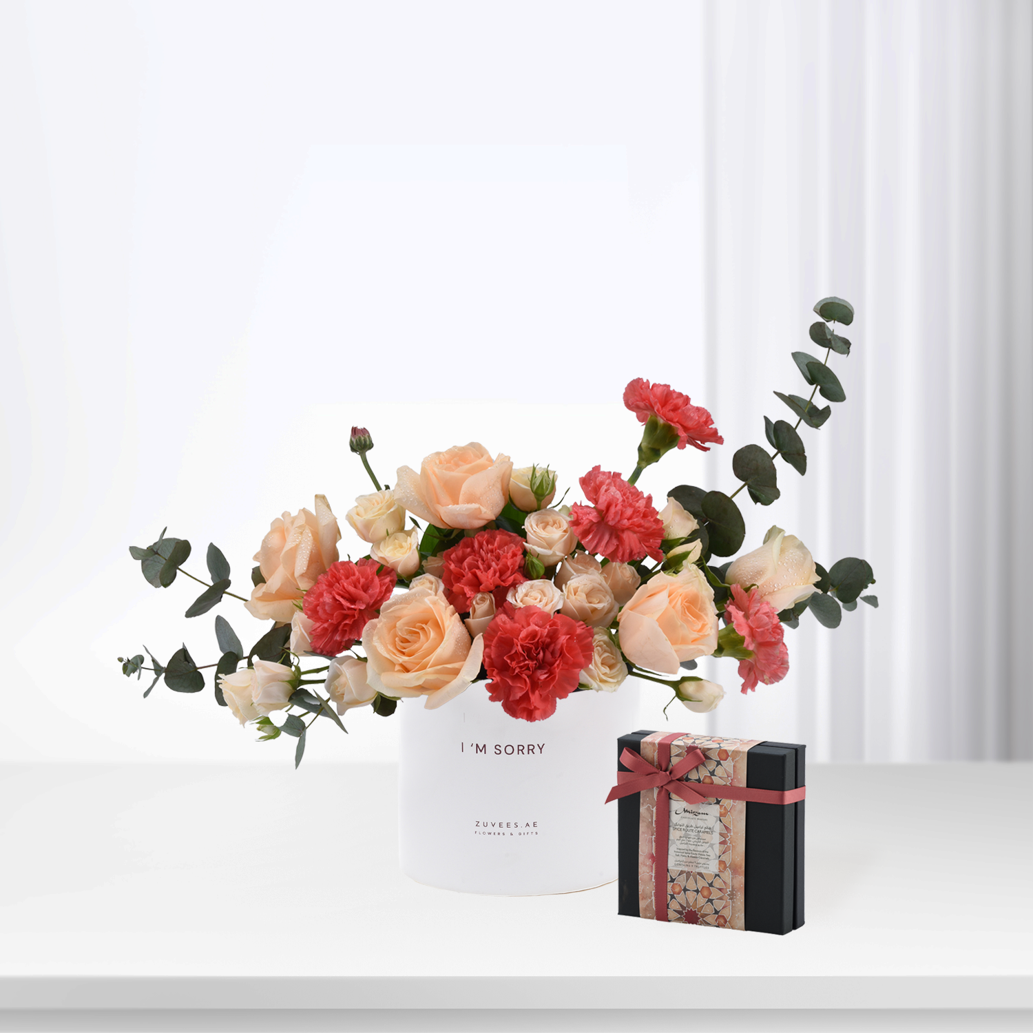 Soft peach roses and red carnations in white box with “I’m Sorry” message.