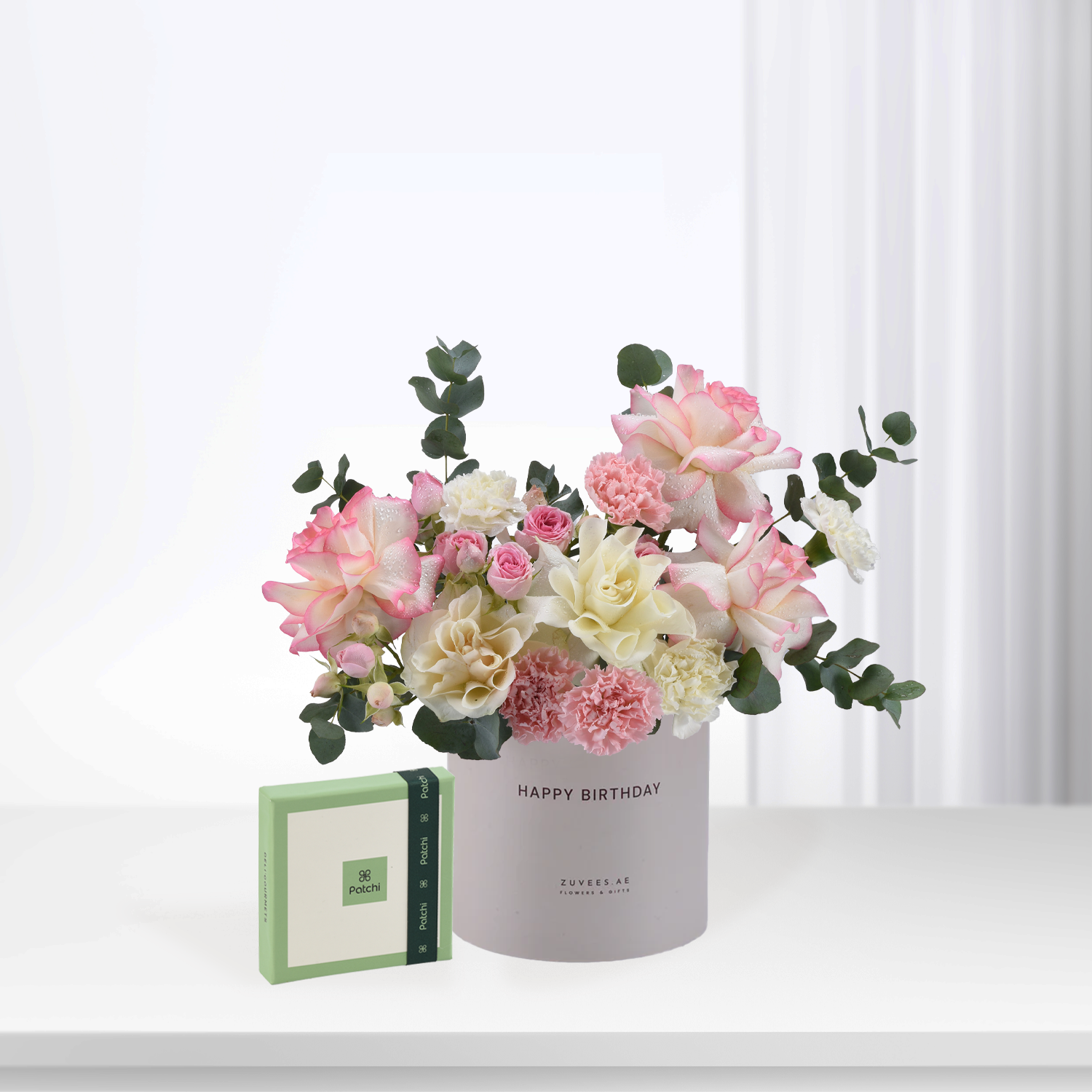 Soft pink, white roses and carnations in gray "Happy Birthday" vase with Patchi gift box.