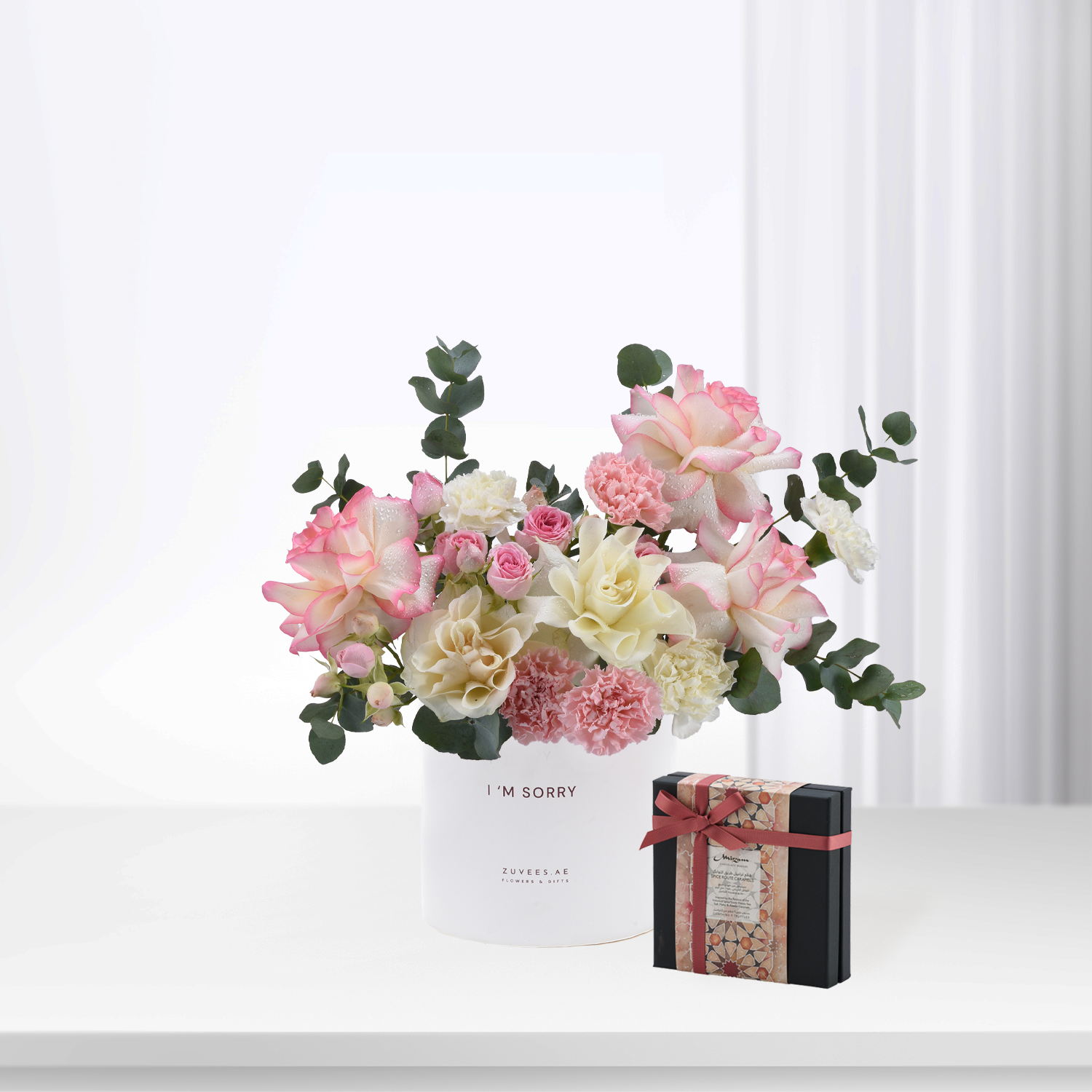 Soft pink and cream roses with eucalyptus in white vase reading "I&