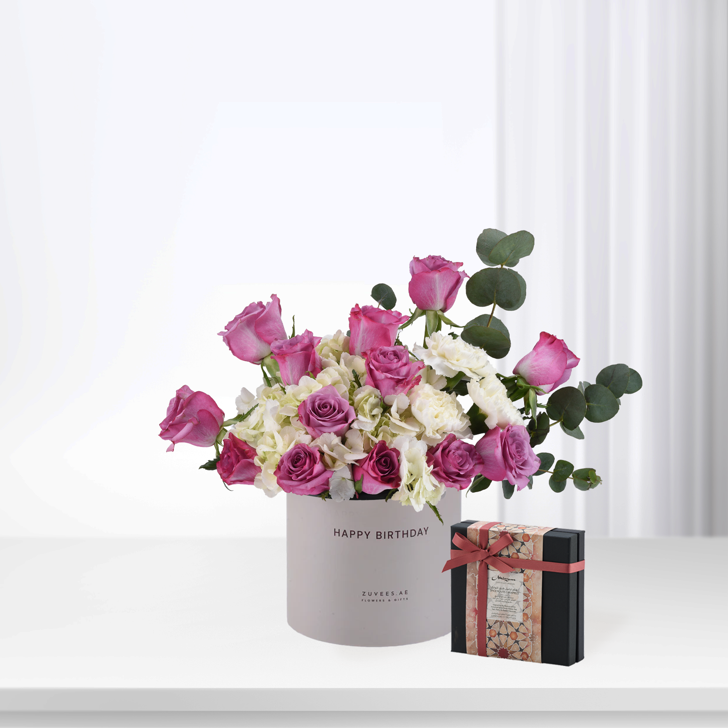 Pink roses and white hydrangeas in gray "Happy Birthday" box with chocolate gift.