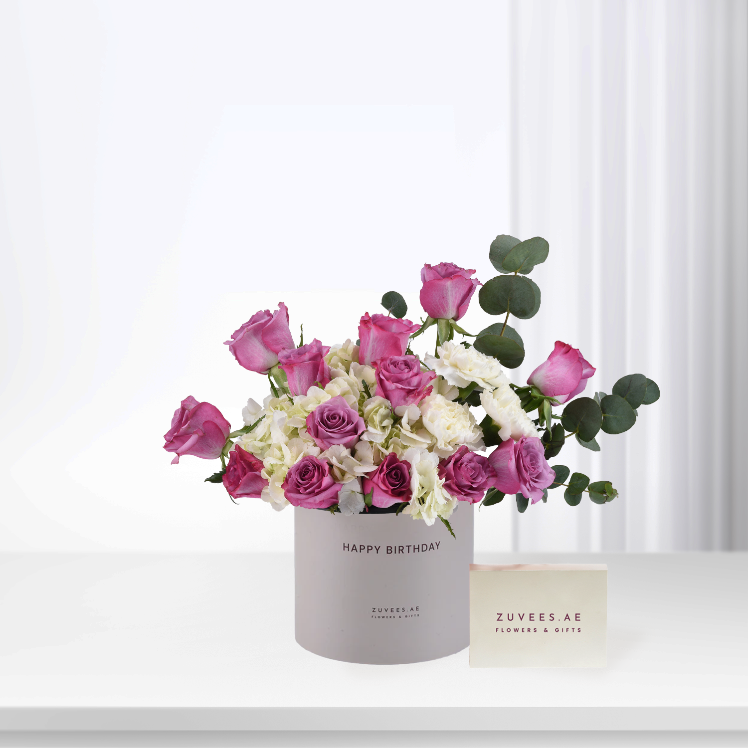 Pink roses and white hydrangeas in a "Happy Birthday" cylinder box.