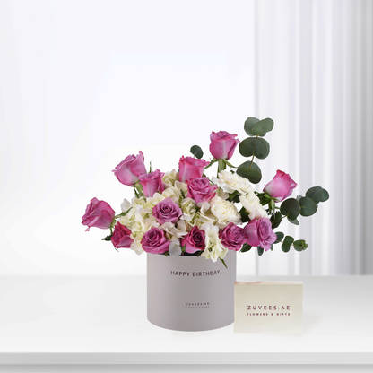 Pink roses and white hydrangeas in a "Happy Birthday" cylinder box.