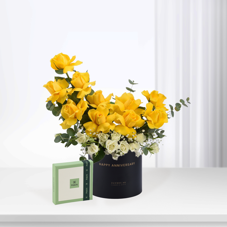 Vibrant yellow roses with white accents in black "Happy Anniversary" box, paired with green Patchi chocolate gift.