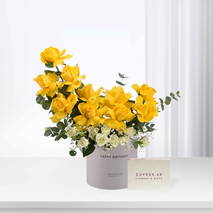 Vibrant yellow roses and white blooms in sleek gray birthday box.