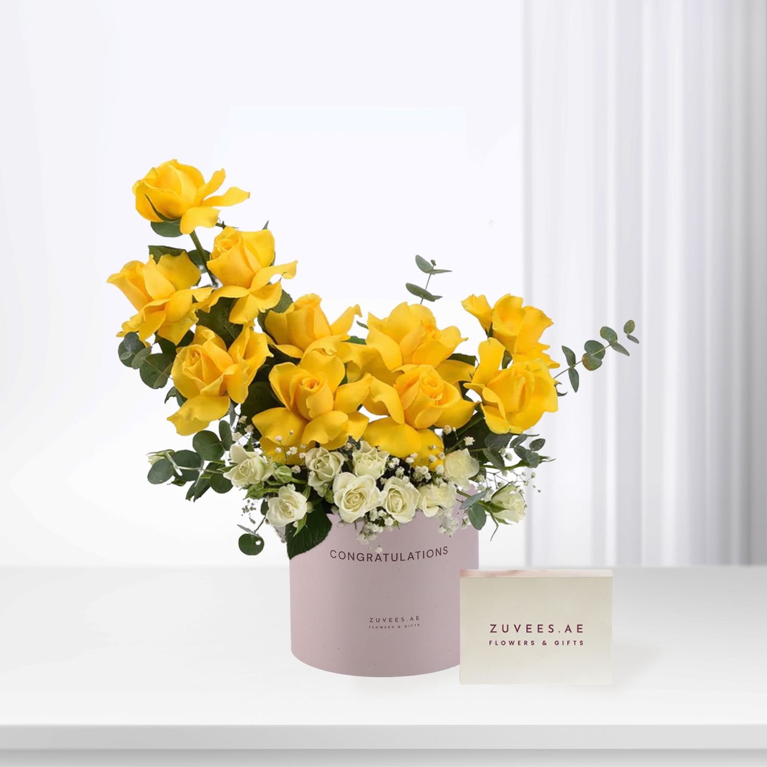 Vibrant yellow roses with white accents in a pink "Congratulations" box.