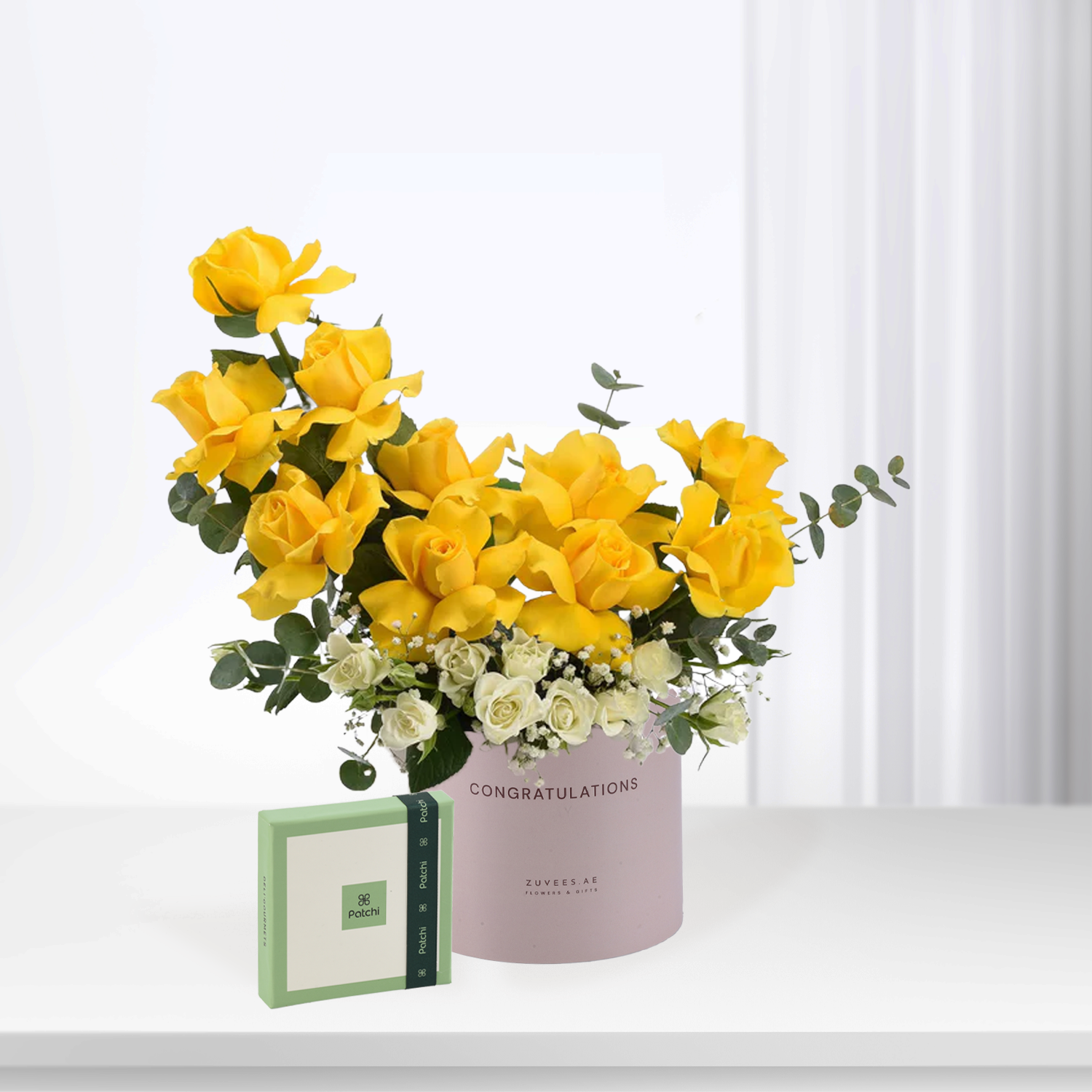 Vibrant yellow roses with white accents in pink "CONGRATULATIONS" box, paired with green Patchi gift box.