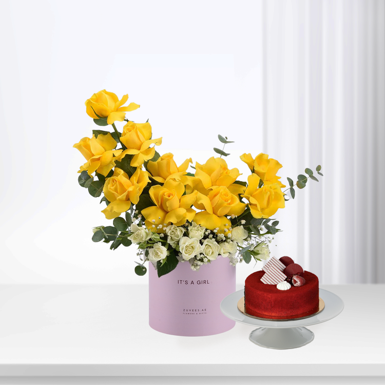 Vibrant yellow roses and white blooms in lilac box beside red velvet cake.