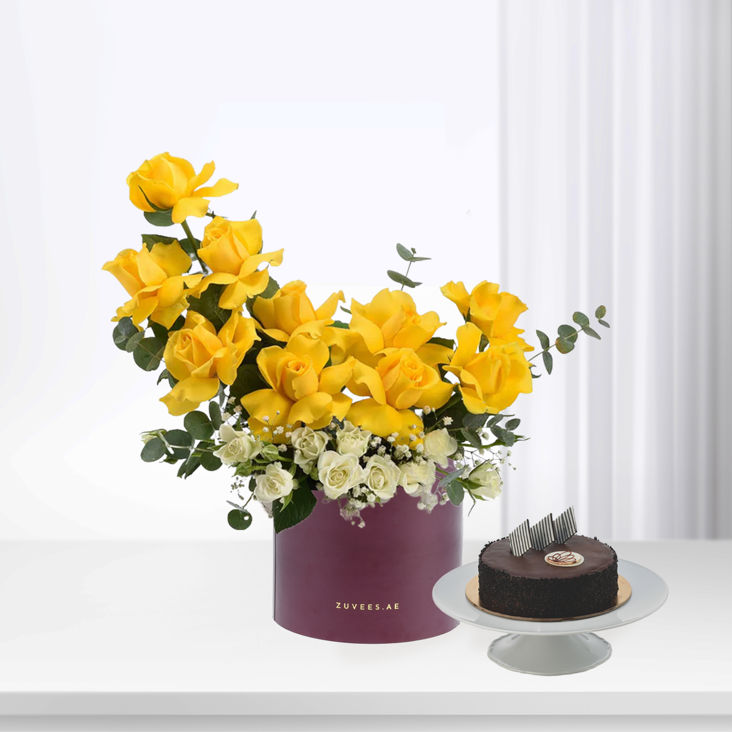 Vibrant yellow roses with white accents in burgundy box, paired with chocolate cake, elegant gift set.