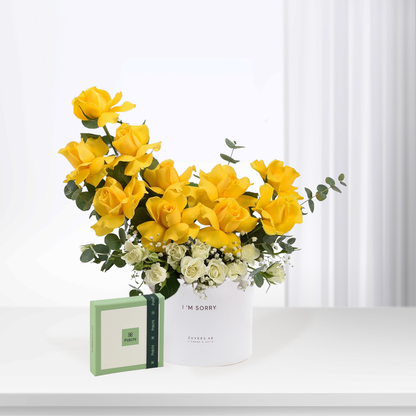 Vibrant yellow roses in white box with “I&