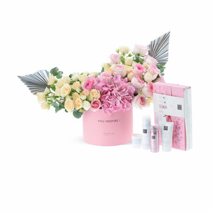 Pink floral arrangement with silver accents and matching skincare set.