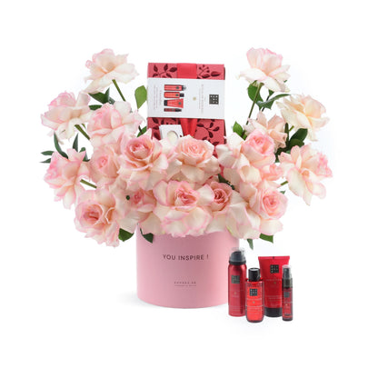 Pink roses in branded cylinder, surrounded by Rituals skincare set.
