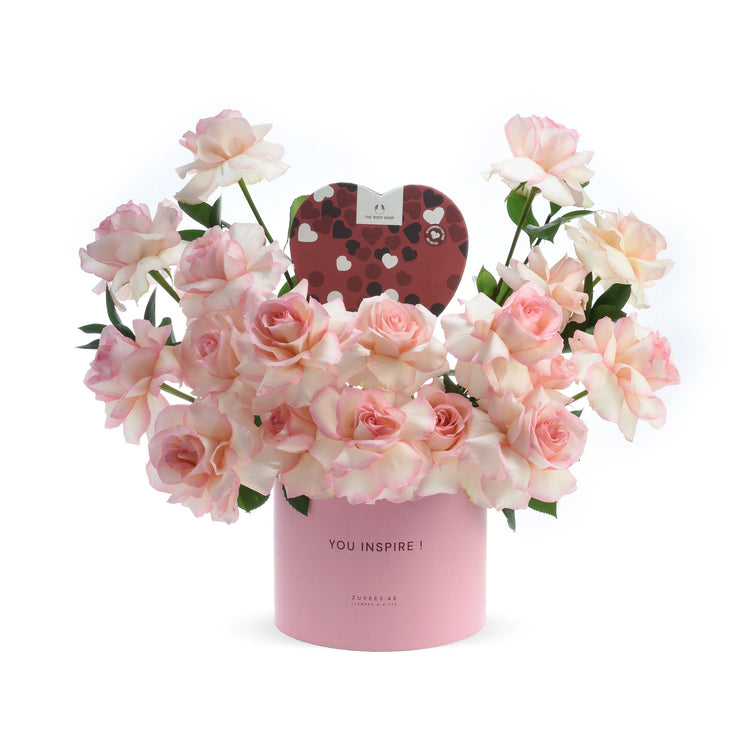 Pink roses in a "YOU INSPIRE!" box with heart-shaped chocolate gift, elegant and romantic.