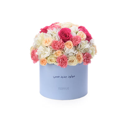 Pastel pink, peach, and white blooms in a light blue box with Arabic “Newborn” text.