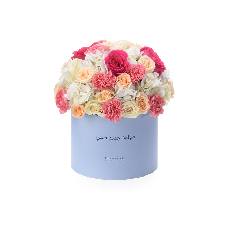 Pastel pink, peach, and white blooms in a light blue box with Arabic “Newborn” text.