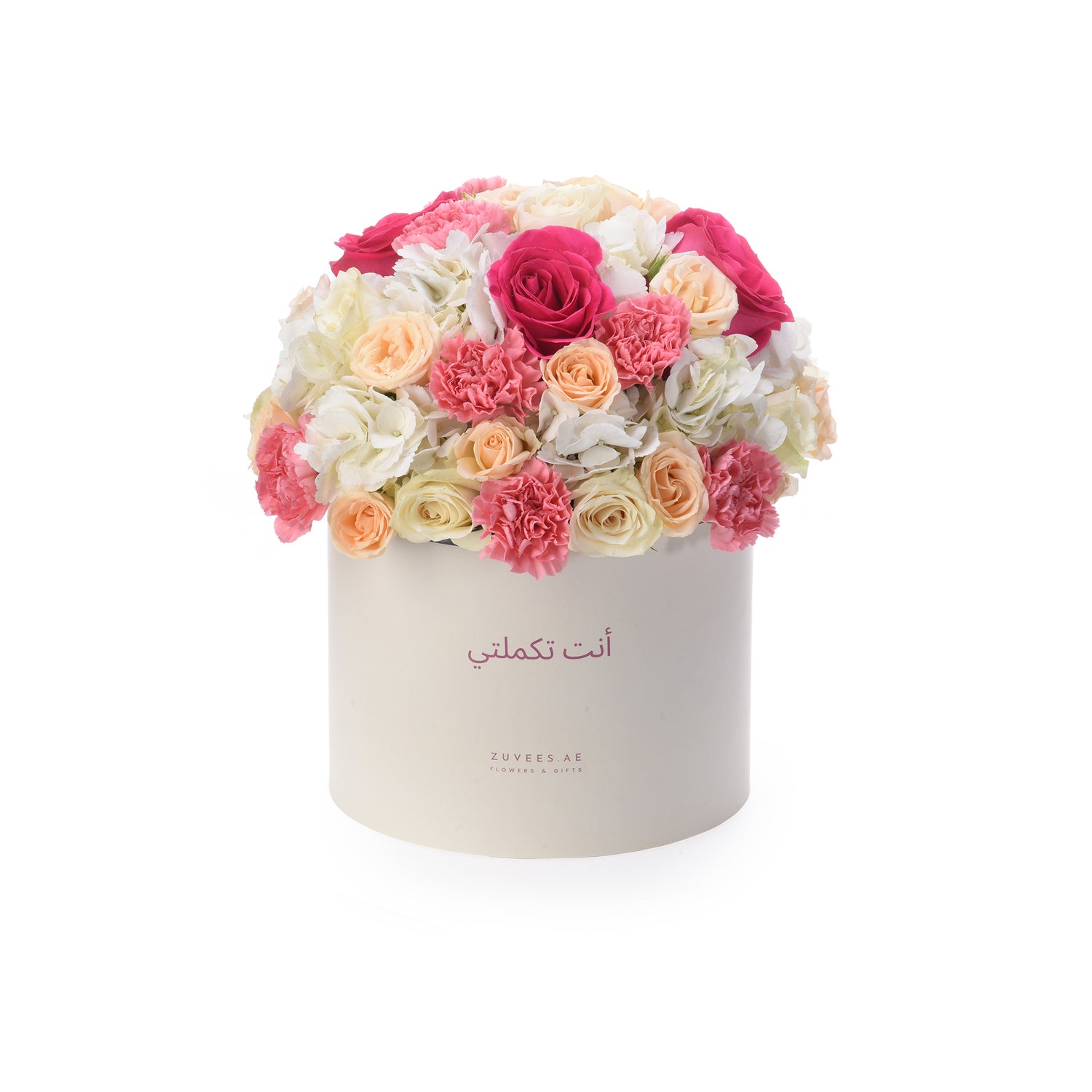 Cream box holds vibrant pink, peach, and white roses and carnations.
