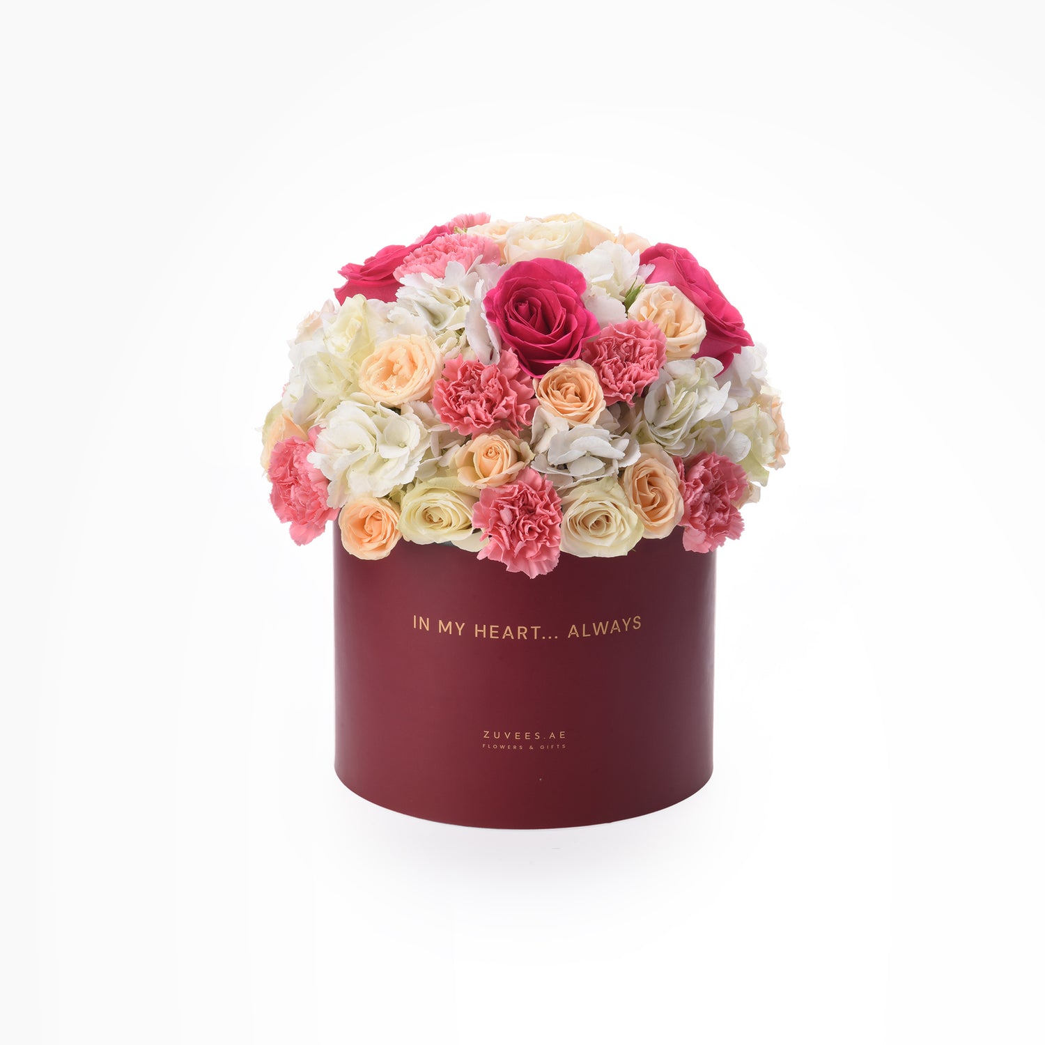 Vibrant pink, peach, and white roses and carnations in elegant burgundy box with gold "In My Heart... Always" text.