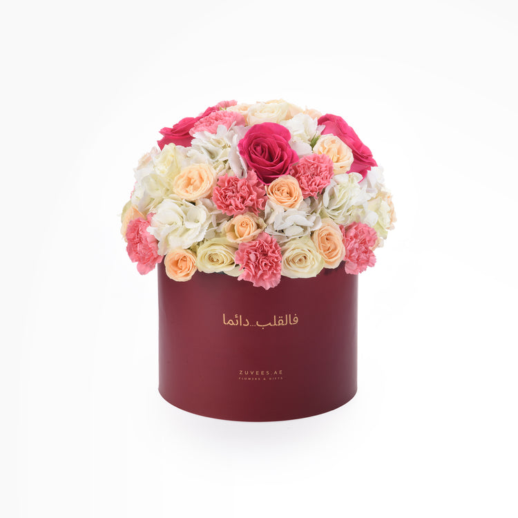 Vibrant pink, peach, and white roses &amp; carnations in elegant burgundy hat box.