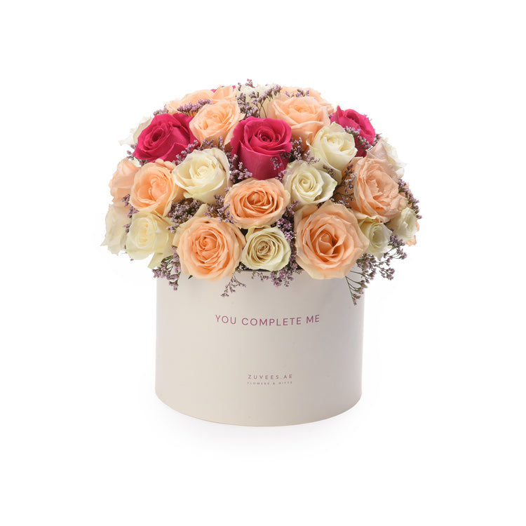 Pastel peach, white, and magenta roses in cream box with "You Complete Me" message.