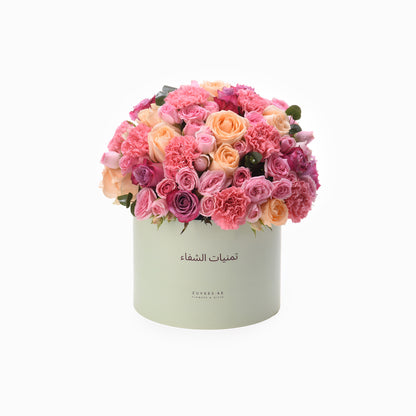 Pastel pink and peach roses and carnations in mint green box.