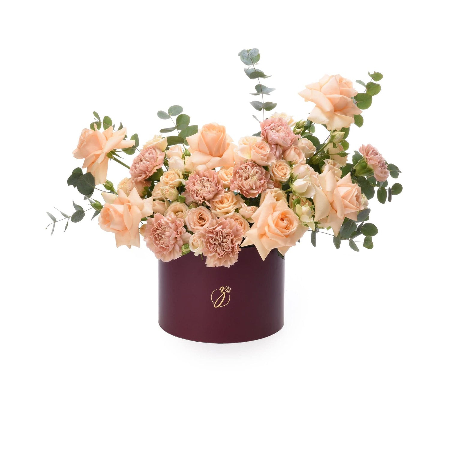 Elegant peach roses and carnations in burgundy box with gold logo.