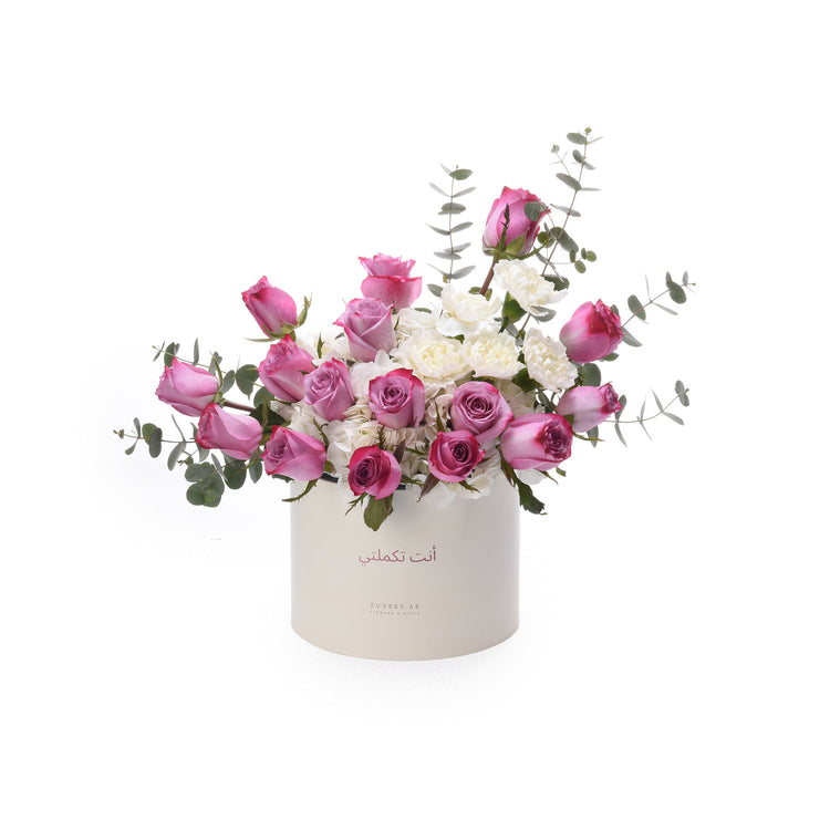 Pink roses, white carnations, eucalyptus in elegant white Zuvees box with Arabic script.