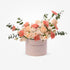 Soft pink box with “CONGRATULATIONS” text, holding peach roses and carnations with eucalyptus.